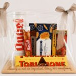 Luxe geschenkpakket met Belgische chocolade, koekjes en zoete lekkernijen stijlvol verpakt op houten serveerplank 🎁✨